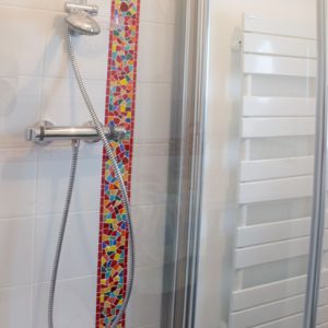 Décor de douche en mosaïque colorée en Émaux de Briare, pâte de verre et cabochons